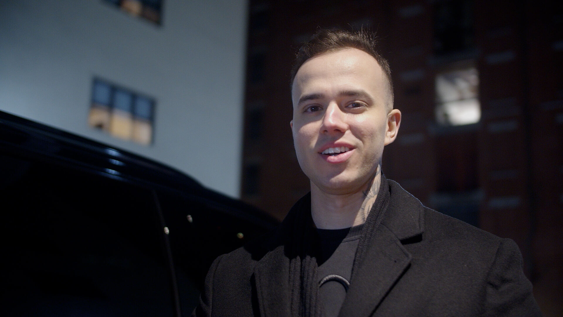 Suited chauffeur opening door for a corporate client